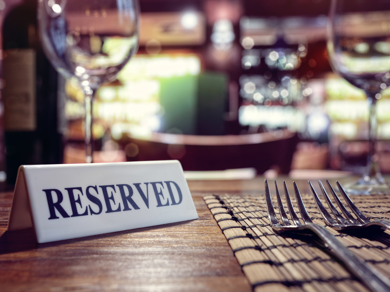 Reserved sign on restaurant table with bar background